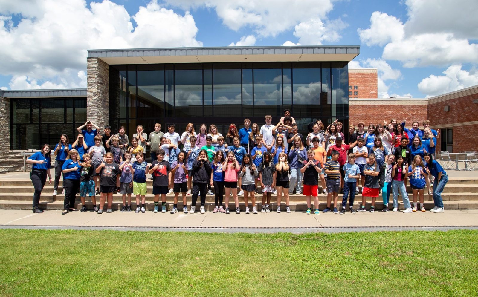 Large group of students posing in front of a building