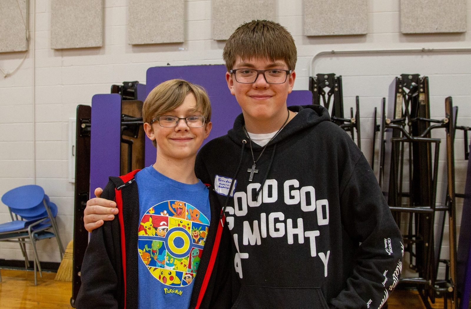 Two students posing side-by-side in a gym