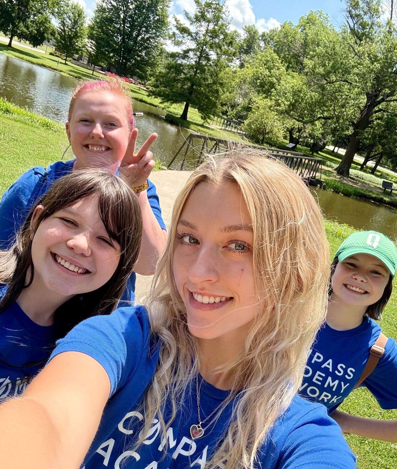 Students posing outside near a pond